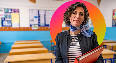 Education employee smiling in a well-lit empty classroom 